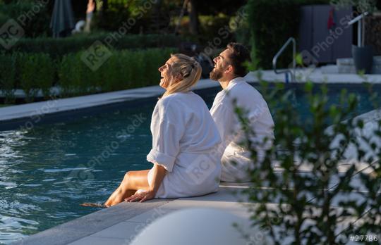 Couple in white robes seated by a pool looking up and laughing a day in a spa hotel  : Stock Photo or Stock Video Download rcfotostock photos, images and assets rcfotostock | RC Photo Stock.: