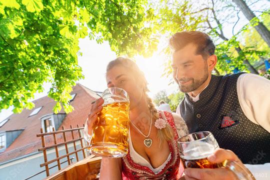 Couple sitting in Beer garden or oktoberfest at summer and enjoy a glass of beer and the sun  : Stock Photo or Stock Video Download rcfotostock photos, images and assets rcfotostock | RC Photo Stock.: