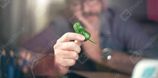 Creative designer looks at green pepper, hot chili pepper  : Stock Photo or Stock Video Download rcfotostock photos, images and assets rcfotostock | RC Photo Stock.: