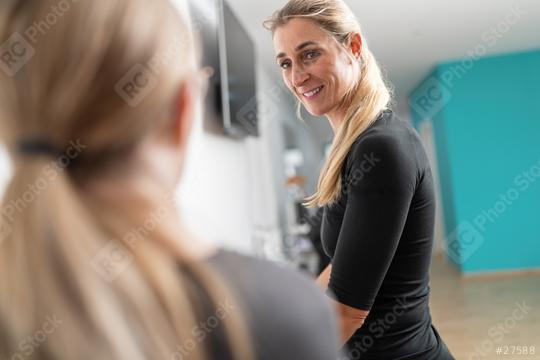 Customer in a gym has a conversation with a trainer during a check-up, she is smiling and cheerful.  : Stock Photo or Stock Video Download rcfotostock photos, images and assets rcfotostock | RC Photo Stock.: