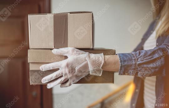 Delivery services courier during the Coronavirus (COVID-19) pandemic, close-up of cardboard box holding by a courier wearing   : Stock Photo or Stock Video Download rcfotostock photos, images and assets rcfotostock | RC Photo Stock.: