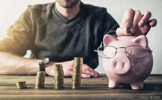 Depositing money in a piggy bank  : Stock Photo or Stock Video Download rcfotostock photos, images and assets rcfotostock | RC Photo Stock.: