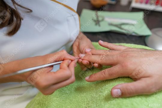 Detailed view of a manicure with a cuticle pusher being used on a fingernail of a male client. body care spa treatment concept image  : Stock Photo or Stock Video Download rcfotostock photos, images and assets rcfotostock | RC Photo Stock.: