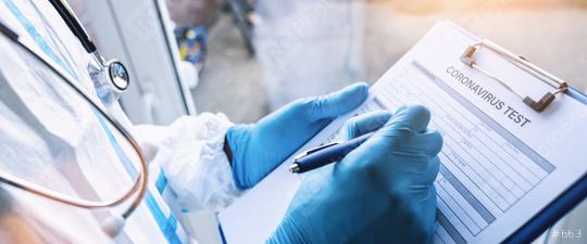Doctor fills out a coronavirus test data sheet with pen in protective clothing in a clinic leaning against window at Covid-19 coronavirus epidemic  : Stock Photo or Stock Video Download rcfotostock photos, images and assets rcfotostock | RC Photo Stock.: