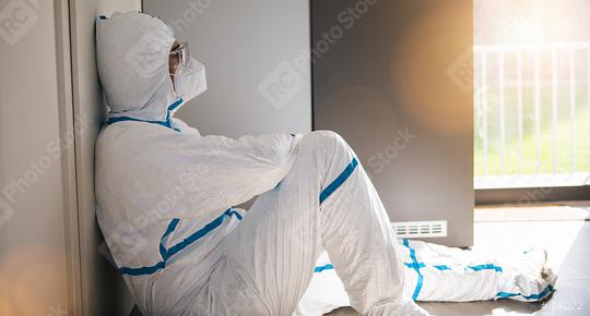 Doctor lies in protective clothing with stress and burnout in clinic leaning against window at Covid-19 coronavirus epidemic  : Stock Photo or Stock Video Download rcfotostock photos, images and assets rcfotostock | RC Photo Stock.: