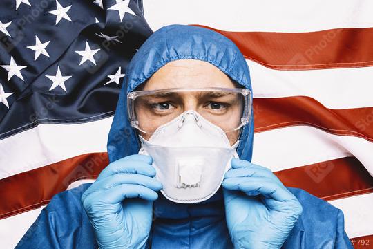 Doctor wearing protection Suit for Fighting Covid-19 (Corona virus) SARS infection Protective Equipment (PPE), Against The American Flag Banner.   : Stock Photo or Stock Video Download rcfotostock photos, images and assets rcfotostock | RC Photo Stock.: