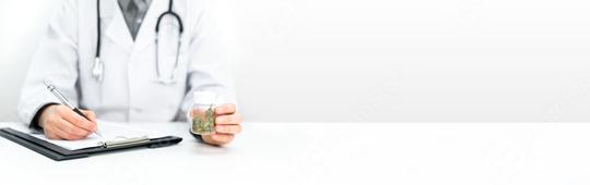 Doctor writing a prescription. He is holding a bottle of medical CBD cannabis in his hand. Legal healing cannabis for alternative medicine.  : Stock Photo or Stock Video Download rcfotostock photos, images and assets rcfotostock | RC Photo Stock.: