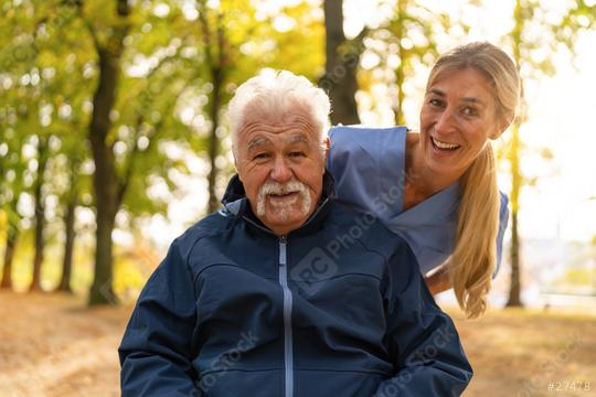 Elderly man in a wheelchair sharing a joyful moment with a nurse in a sunlit park, both smiling warmly  : Stock Photo or Stock Video Download rcfotostock photos, images and assets rcfotostock | RC Photo Stock.: