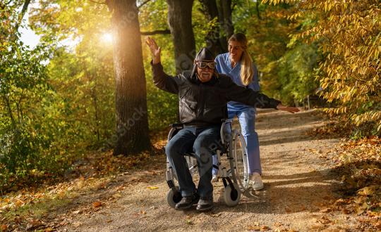 Elderly man in a wheelchair wearing an aviator uniform and goggles, with a joyful expression in an autumn park  : Stock Photo or Stock Video Download rcfotostock photos, images and assets rcfotostock | RC Photo Stock.: