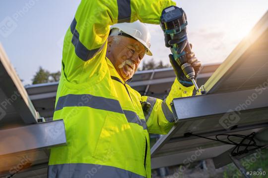 Engineer using a cordless drill to install solar panels at dawn. Alternative energy ecological concept image.  : Stock Photo or Stock Video Download rcfotostock photos, images and assets rcfotostock | RC Photo Stock.: