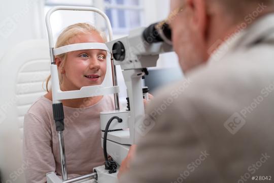 Eye examination with young girl looking into an optometry machine at eye clinic  : Stock Photo or Stock Video Download rcfotostock photos, images and assets rcfotostock | RC Photo Stock.: