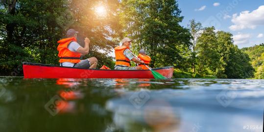 Family canoeing on a river, father paddling in the foreground, with lush green trees and bright sunlight in germany. Family on kayak ride. Wild nature and water fun on summer vacation.  : Stock Photo or Stock Video Download rcfotostock photos, images and assets rcfotostock | RC Photo Stock.: