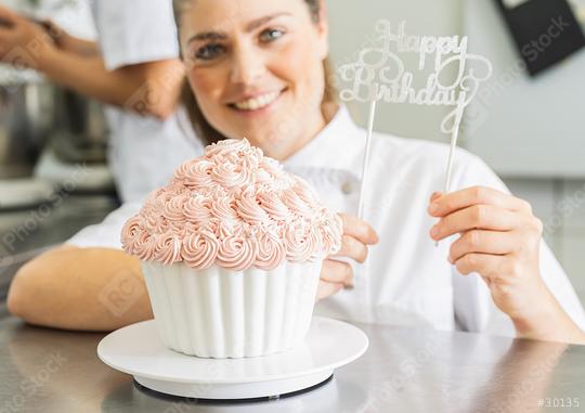 female confectioner decorating big Birthday cake muffin with candies at pastry bakery  : Stock Photo or Stock Video Download rcfotostock photos, images and assets rcfotostock | RC Photo Stock.: