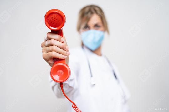 Female Doctor wearing N95 FFP2 an anti virus protection mask to prevent others from corona COVID-19 and SARS cov 2 infection and Holding Telephone Receiver  : Stock Photo or Stock Video Download rcfotostock photos, images and assets rcfotostock | RC Photo Stock.: