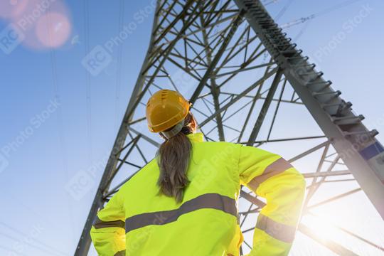 female electrical engineer standing and watching at the electric power station to view the planning work by producing electricity at high voltage electricity poles.  : Stock Photo or Stock Video Download rcfotostock photos, images and assets rcfotostock | RC Photo Stock.: