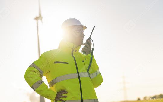 female engineer with safety jacket using walkie talkie to checking wind turbine system at new enegry farm  : Stock Photo or Stock Video Download rcfotostock photos, images and assets rcfotostock | RC Photo Stock.: