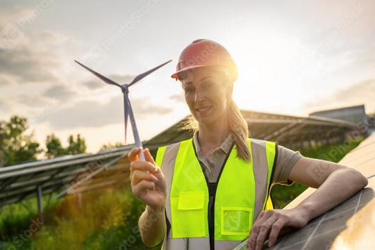 Female engineer with wind turbine model at solar energy farm photovoltaic panel system at sunset. Alternative energy ecological concept.  : Stock Photo or Stock Video Download rcfotostock photos, images and assets rcfotostock | RC Photo Stock.: