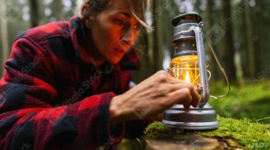 Female Hiker looking a kerosene lamp or oil lamp in the forest. authentic close-up shot. Travel concept image  : Stock Photo or Stock Video Download rcfotostock photos, images and assets rcfotostock | RC Photo Stock.: