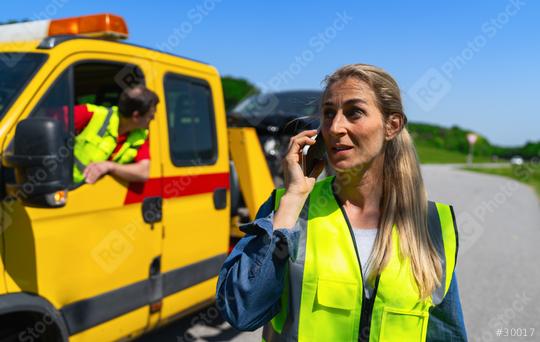female motorist talks on the phone after the towing service has loaded her car onto a Tow truck and explains her problem. Roadside assistance concept image.  : Stock Photo or Stock Video Download rcfotostock photos, images and assets rcfotostock | RC Photo Stock.: