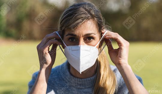 Female Student wearing N95 FFP2 an anti virus protection mask to prevent others from coronavirus COVID-19 and SARS cov 2 infection in a park at spring.   : Stock Photo or Stock Video Download rcfotostock photos, images and assets rcfotostock | RC Photo Stock.: