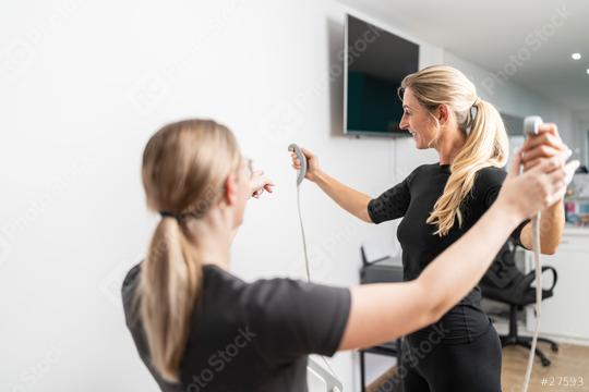 Female Trainer explaining the usage of a body composition measuring scale, client holding analyzer handles extending towards in a gym.  : Stock Photo or Stock Video Download rcfotostock photos, images and assets rcfotostock | RC Photo Stock.: