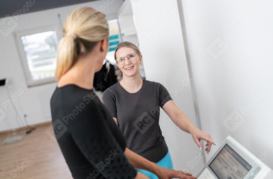 Female trainer pointing at a body composition scale’s display to explaine her customer the function for a  Inbody test in a fitness Studio  : Stock Photo or Stock Video Download rcfotostock photos, images and assets rcfotostock | RC Photo Stock.: