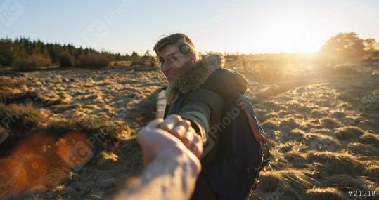 first view of woman hiker with backpack stands on a boardwalk in the bog landscape against background of sunrise and holding a hand  : Stock Photo or Stock Video Download rcfotostock photos, images and assets rcfotostock | RC Photo Stock.: