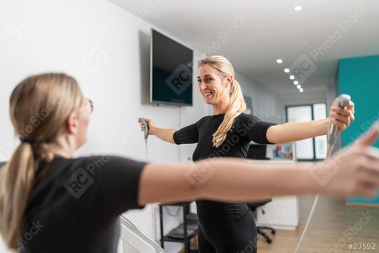 fitness client smiling while holding body composition scale analyzer handles Inbody test, extending arms towards the trainer in a EMS - Studio.  : Stock Photo or Stock Video Download rcfotostock photos, images and assets rcfotostock | RC Photo Stock.: