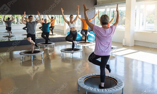 Fitness enthusiasts participating in a trampoline workout class in a sunny gym  : Stock Photo or Stock Video Download rcfotostock photos, images and assets rcfotostock | RC Photo Stock.: