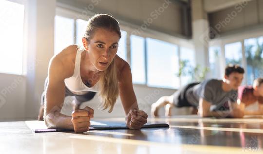 Fitness woman doing plank exercise workout in a group of people in gym. Sport girl and men in sportswear doing exercising on yoga mat, planking indoors  : Stock Photo or Stock Video Download rcfotostock photos, images and assets rcfotostock | RC Photo Stock.: