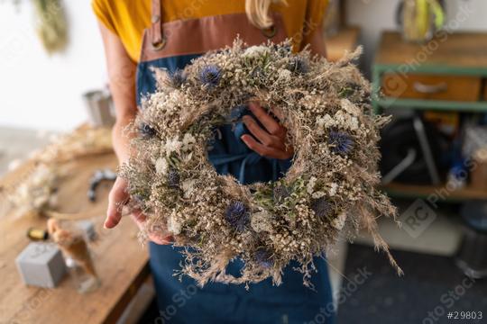 Florist presenting a nearly finished dried flower wreath, showcasing its textures and colors  : Stock Photo or Stock Video Download rcfotostock photos, images and assets rcfotostock | RC Photo Stock.: