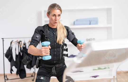 Focused woman exercising with dumbbells on a training computer in EMS suit at a fitness studio  : Stock Photo or Stock Video Download rcfotostock photos, images and assets rcfotostock | RC Photo Stock.: