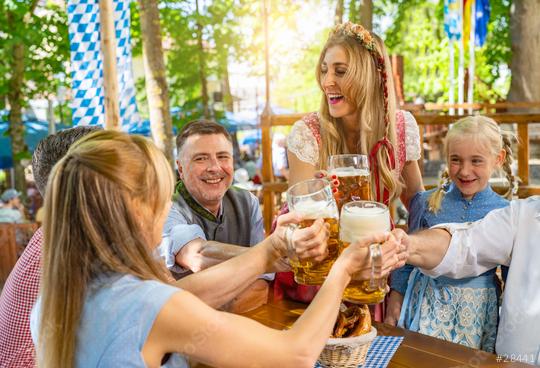 friends and family in Tracht, Dirndl and Lederhosen having fun sitting on table drinking beer and eating pretzels in Beer garden or oktoberfest in Bavaria, Germany  : Stock Photo or Stock Video Download rcfotostock photos, images and assets rcfotostock | RC Photo Stock.: