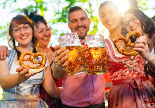 friends in Tracht, Dirndl and Lederhosen having fun drinking beer and eating pretzels in Beer garden or oktoberfest in Bavaria, Germany  : Stock Photo or Stock Video Download rcfotostock photos, images and assets rcfotostock | RC Photo Stock.: