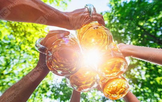 Friends toasting and drinking beer at beer garden. Friendship life style and party at Oktoberfest, folk or beer festival, with bright sunlight  : Stock Photo or Stock Video Download rcfotostock photos, images and assets rcfotostock | RC Photo Stock.: