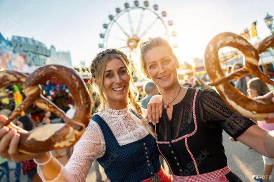 Friends visiting together a Bavarian fair or oktoberfest or duld in national costume or Dirndl with pretzel or brezen  : Stock Photo or Stock Video Download rcfotostock photos, images and assets rcfotostock | RC Photo Stock.: