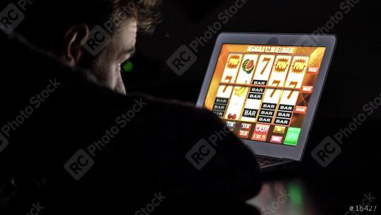 Gambling addicted man with glasses in front of online casino slot machine on laptop computer at night - loosing his money. Dramatic low light grain shot.  : Stock Photo or Stock Video Download rcfotostock photos, images and assets rcfotostock | RC-Photo-Stock.: