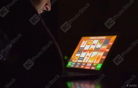 Gambling addicted man with glasses in front of online casino slot machine on laptop computer at night - loosing his money. Dramatic low light grain shot.  : Stock Photo or Stock Video Download rcfotostock photos, images and assets rcfotostock | RC Photo Stock.: