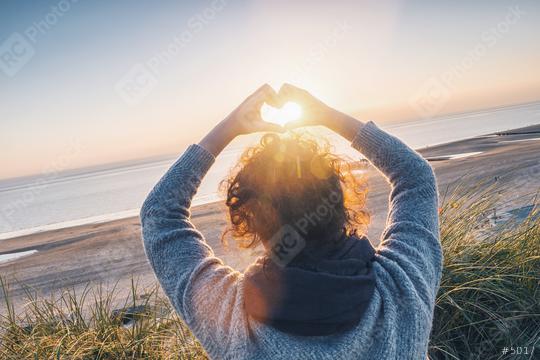 Girl holding a heart-shape with sunset light on the beach  : Stock Photo or Stock Video Download rcfotostock photos, images and assets rcfotostock | RC Photo Stock.: