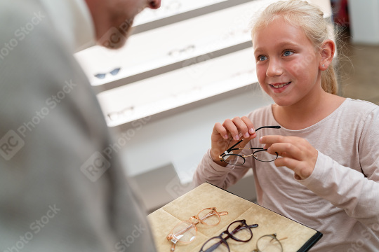 Girl holding glasses with optician and trying on new glasses. Sh  : Stock Photo or Stock Video Download rcfotostock photos, images and assets rcfotostock | RC Photo Stock.: