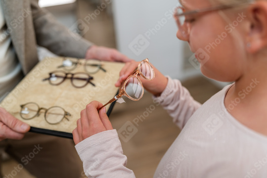 Girl trying on newglasses. She is looking at different frames on  : Stock Photo or Stock Video Download rcfotostock photos, images and assets rcfotostock | RC Photo Stock.: