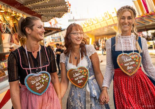 Girlfriends hafing fun at Bavarian fair or oktoberfest in Dirndl with Schenk mir dein Herz, Du bist die beste (German: Give me your heart, you are best ) written on gingerbreads heart  : Stock Photo or Stock Video Download rcfotostock photos, images and assets rcfotostock | RC Photo Stock.: