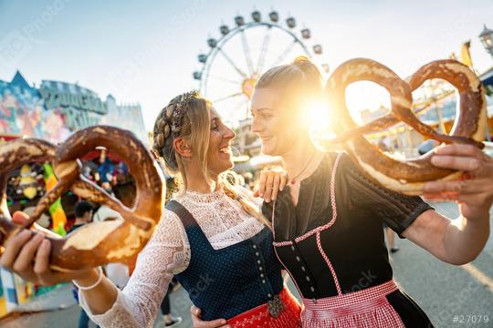girlfriends look to each other with pretzel or brezen on a Bavarian fair or oktoberfest or duld in national costume or Dirndl  : Stock Photo or Stock Video Download rcfotostock photos, images and assets rcfotostock | RC Photo Stock.: