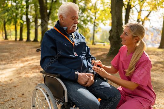 grandpa in wheelchair interacting with caregiver in a park, both smiling, man wearing an SOS button. Dementia retirement home concept image  : Stock Photo or Stock Video Download rcfotostock photos, images and assets rcfotostock | RC Photo Stock.: