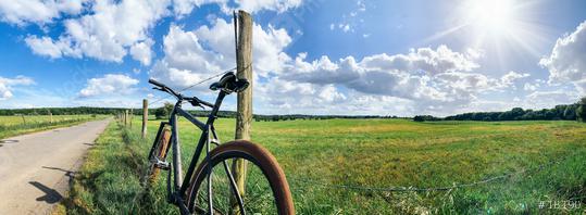 Green field with mountain bike and blue sky. Panoramic view to grass, trees and flowers on the hill on sunny spring day  : Stock Photo or Stock Video Download rcfotostock photos, images and assets rcfotostock | RC Photo Stock.: