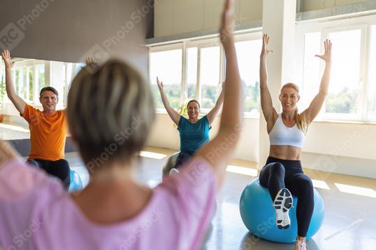 Group of diverse people in a receding line doing pilates in a gym balancing on a gym balls with hands up toning their muscles. Healthy sports lifestyle, Fitness, Healthy concept.  : Stock Photo or Stock Video Download rcfotostock photos, images and assets rcfotostock | RC Photo Stock.: