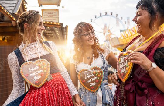 Group of friends in national costume or Dirndl at the Dult, Oktoberfest laugh and have fun at germany, Schenk mir dein Herz (German: Give me your heart) written on gingerbreads souvenir heart  : Stock Photo or Stock Video Download rcfotostock photos, images and assets rcfotostock | RC Photo Stock.:
