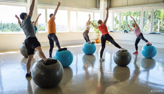 Group of people in a receding line doing pilates in a gym balancing on a gym balls with hands up toning their muscles. Healthy sports lifestyle, Fitness, Healthy concept.  : Stock Photo or Stock Video Download rcfotostock photos, images and assets rcfotostock | RC Photo Stock.: