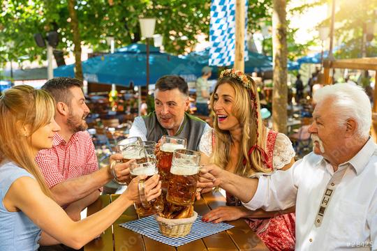 Group of people in proper Tracht toasting and drinking in Bavarian beer garden at summer  : Stock Photo or Stock Video Download rcfotostock photos, images and assets rcfotostock | RC Photo Stock.: