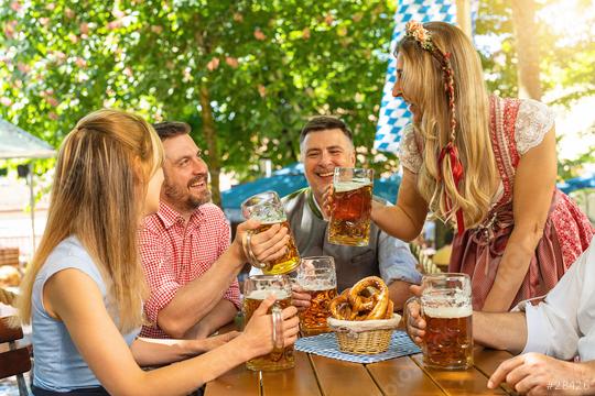 Group of people in proper Tracht toasting and drinking in Bavarian beer garden or oktoberfest at summer in germany  : Stock Photo or Stock Video Download rcfotostock photos, images and assets rcfotostock | RC Photo Stock.: